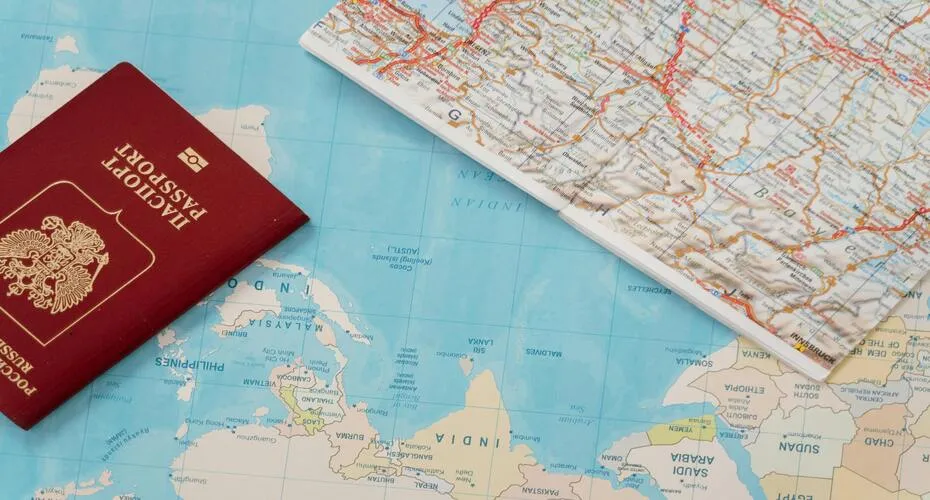 A passport alongside a world map, illustrating the concept of international travel and exploration opportunities.