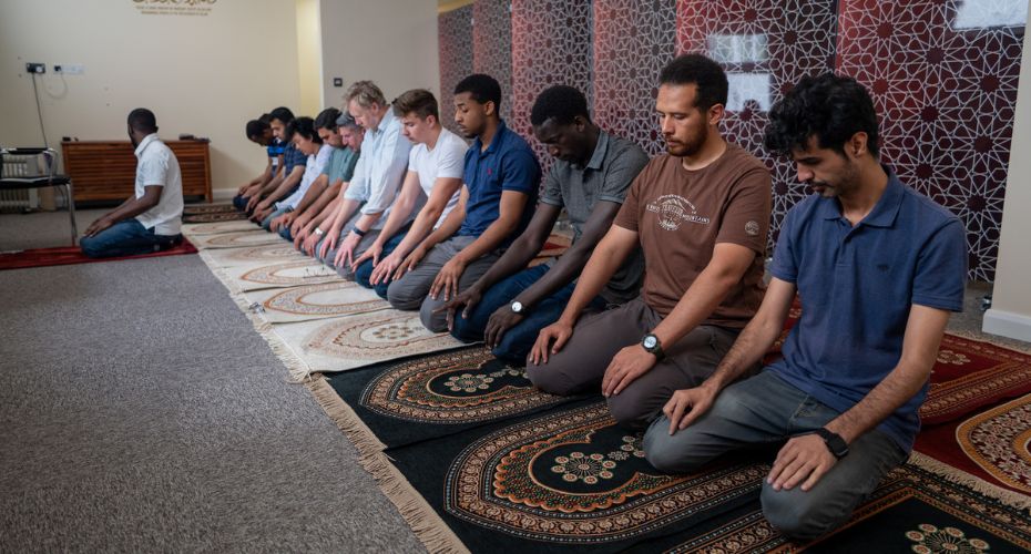 People at prayer in the Muslim Prayer Room